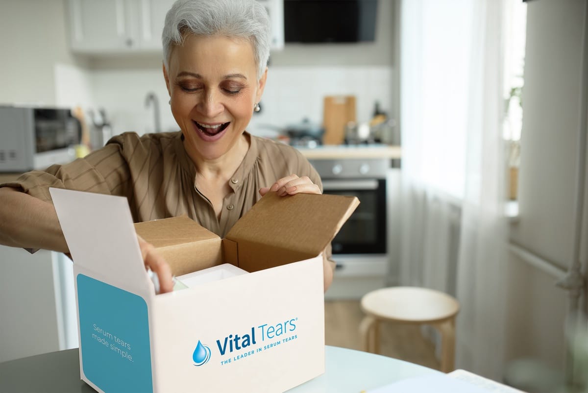 an older woman opens a pharmaceutical package with a surprised look on her face
